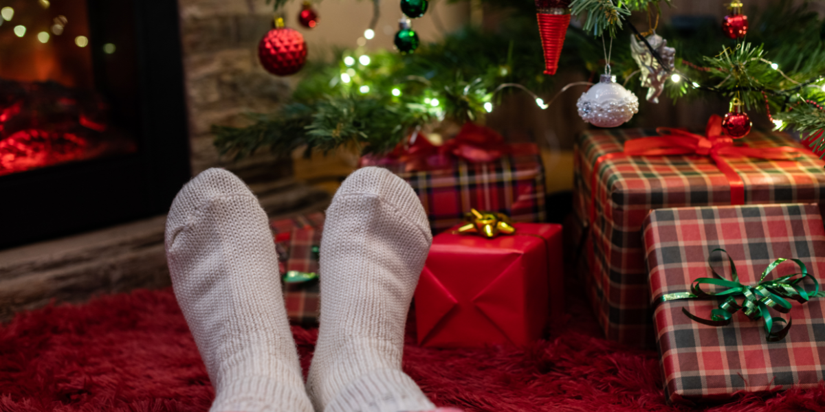 Kilt socks and tartan pajamas near a Christmas tree